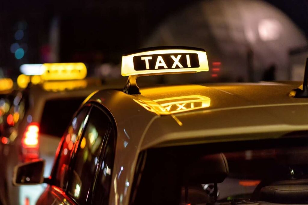 Kogut taxi na dachu taksówki nocą